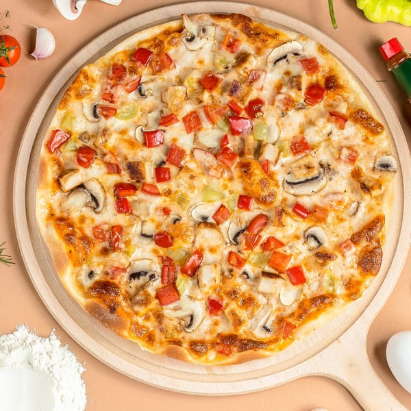 Cestra's Pizza III's chicken, mushroom, and bell pepper pizza on a wooden serving board.